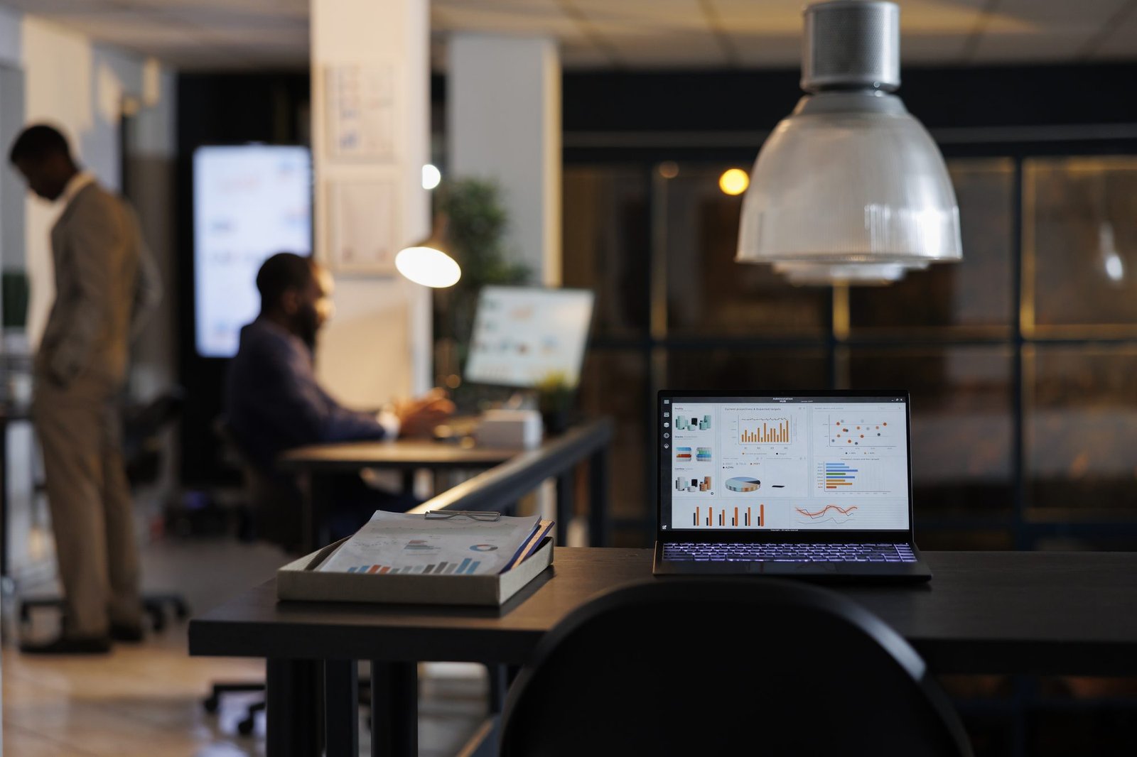 Laptop sobre mesa em pé exibindo estatísticas de marketing
